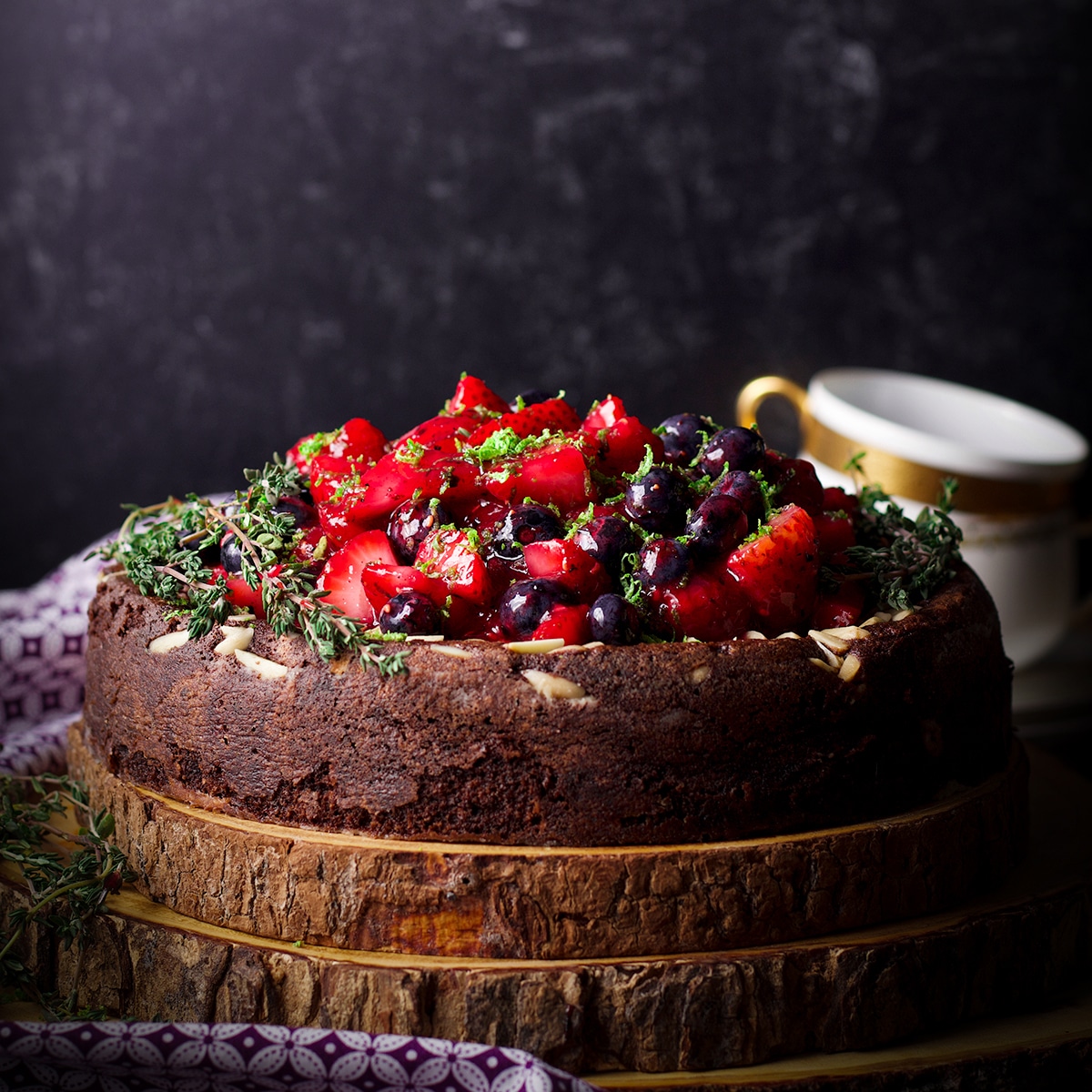 A chocolate ricotta cake made with almond flour covered in fresh berry sauce.