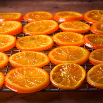 Candied orange slices drying on a wire rack.