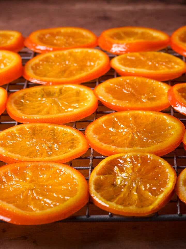Candied orange slices drying on a wire rack.