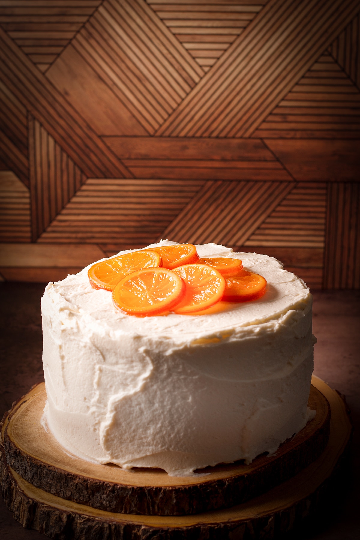 An orange olive oil cake covered in mascarpone frosting and decorated with candied oranges.