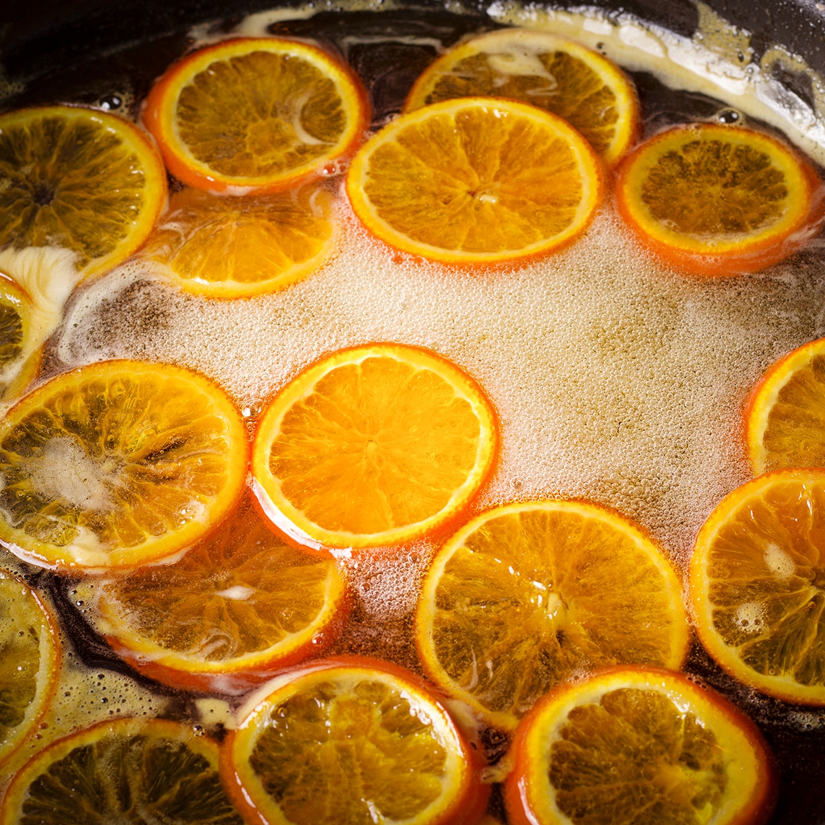 Orange slices simmering in simple syrup.