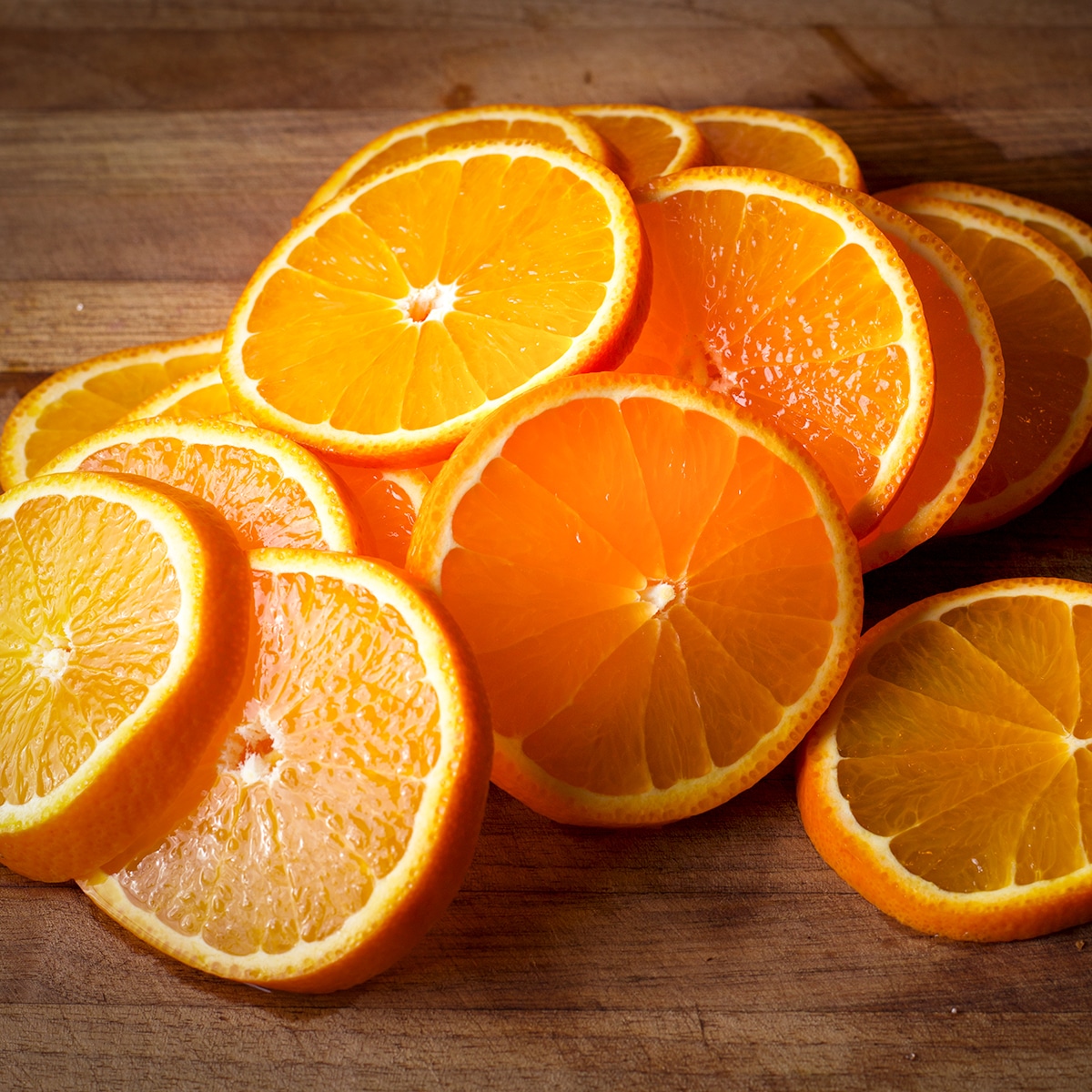 Slices of orange on a wood cutting board.