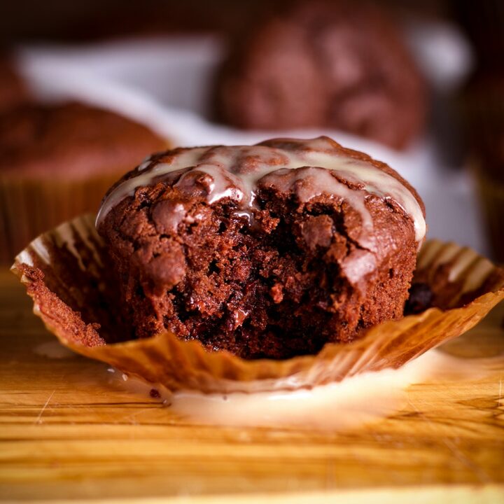 A double chocolate muffin with a bite taken out of it.