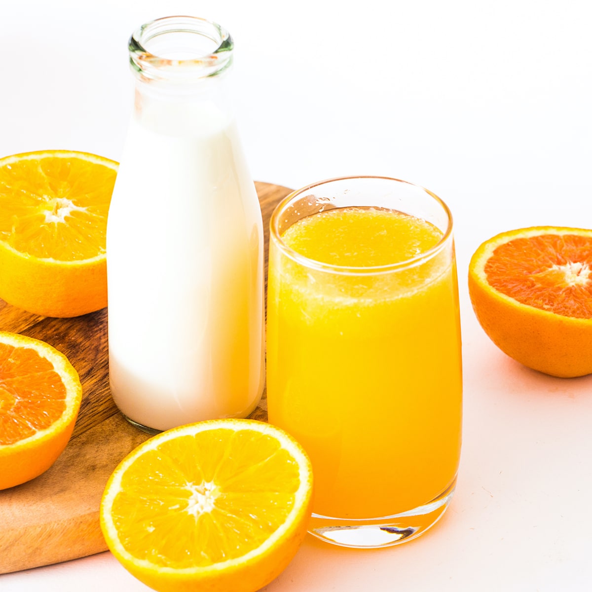A glass jar of buttermilk next to a glass of orange juice.