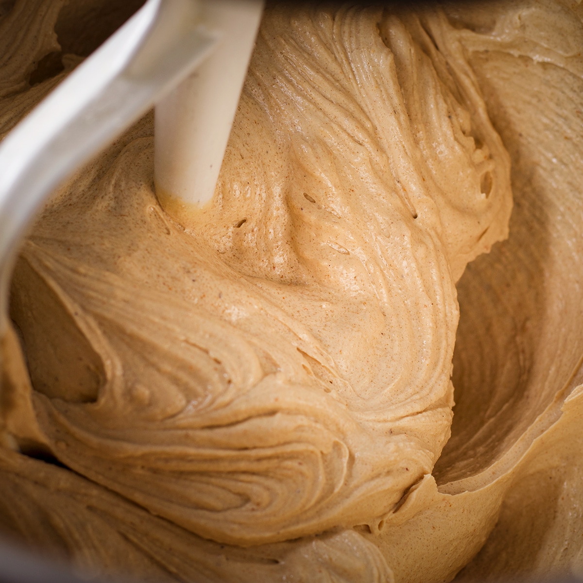 A stand mixer fitted with the paddle attachment mixing cookie dough.