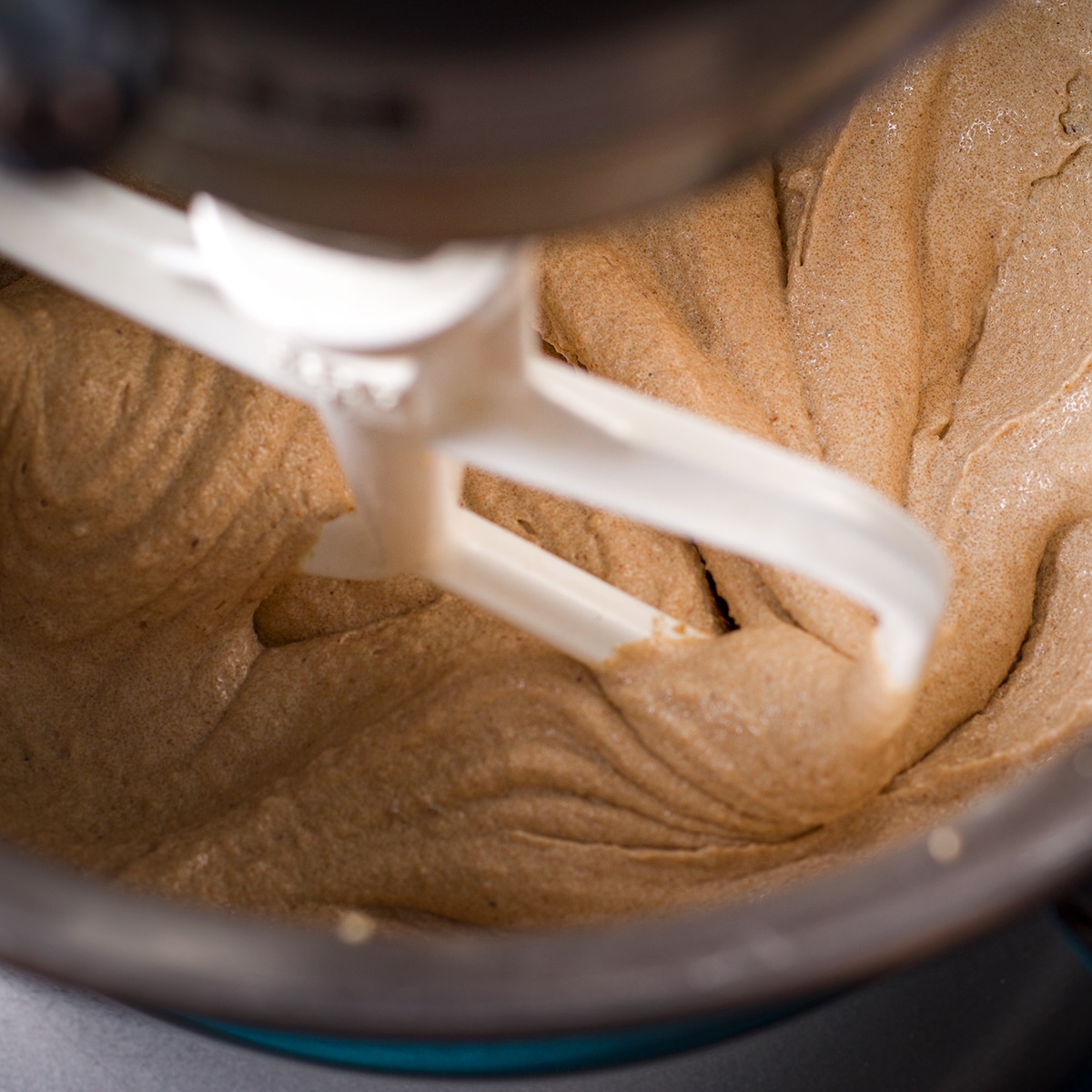 A stand mixer beating butter and sugar.