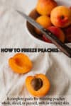 A peach that's been cut in half and is laying next to a bowl full of peaches and a pairing knife.