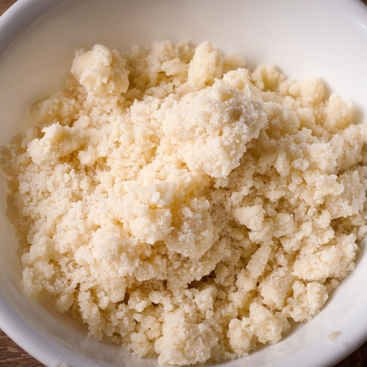 A white bowl filled with butter crumb topping.