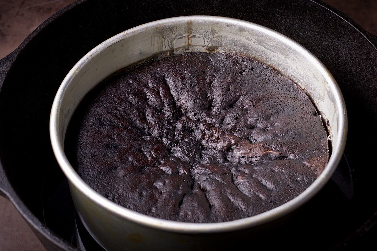 A freshly baked Dutch oven chocolate cake that's still in the cake pan.