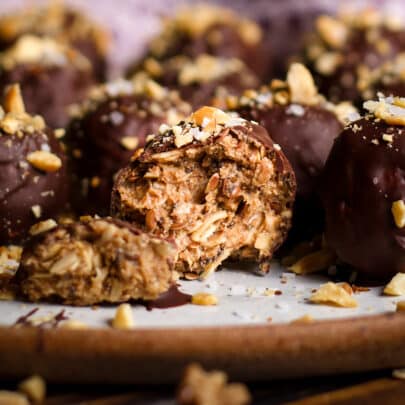 A chocolate covered mocha protein ball that's been broken in half to reveal the peanut butter oat center.