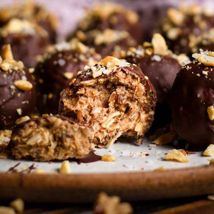 A chocolate covered mocha protein ball that's been broken in half to reveal the peanut butter oat center.